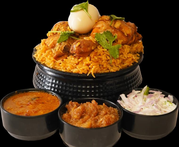 Dum biriyani in a handi with gravy, salna and onion raita